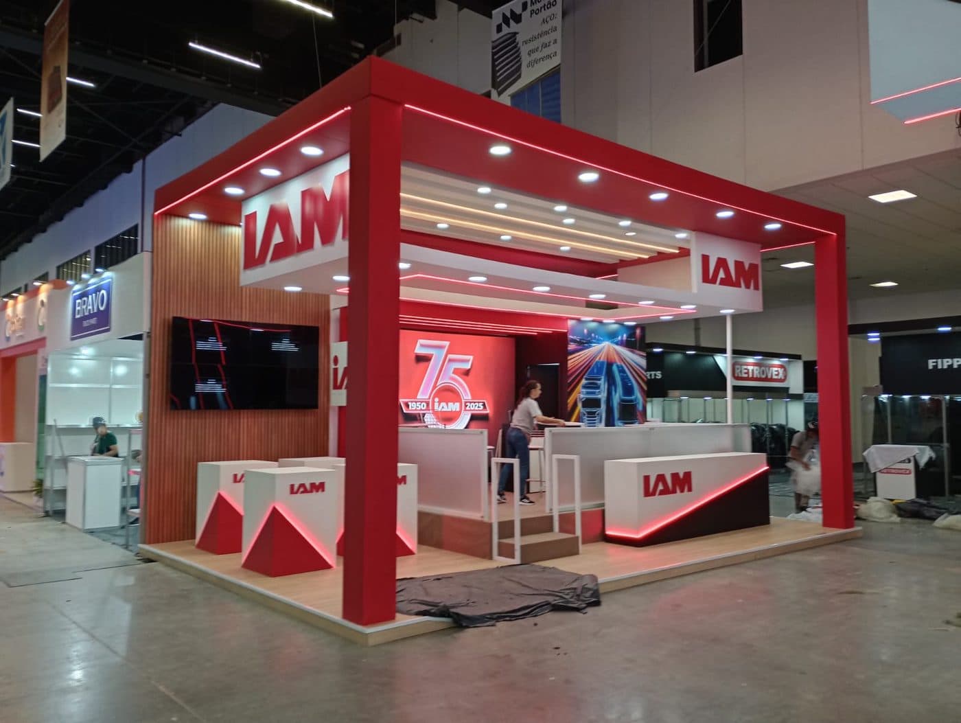 Stand comemorativo dos 75 anos da IAM com pórticos iluminados em vermelho